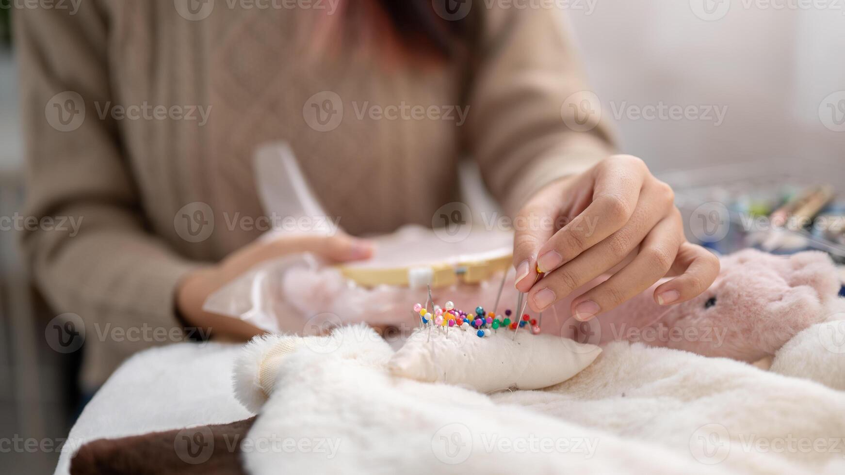 ein Nahansicht Bild von ein Frau feststecken ein Stift auf ein Stift Kissen, Nähen Tuch, basteln handgemacht Artikel. foto