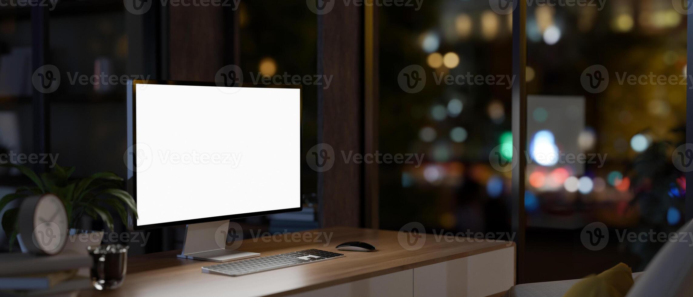 ein zeitgenössisch Wolkenkratzer Büro beim Nacht Eigenschaften ein weißer Bildschirm Computer Attrappe, Lehrmodell, Simulation auf ein hölzern Schreibtisch. foto