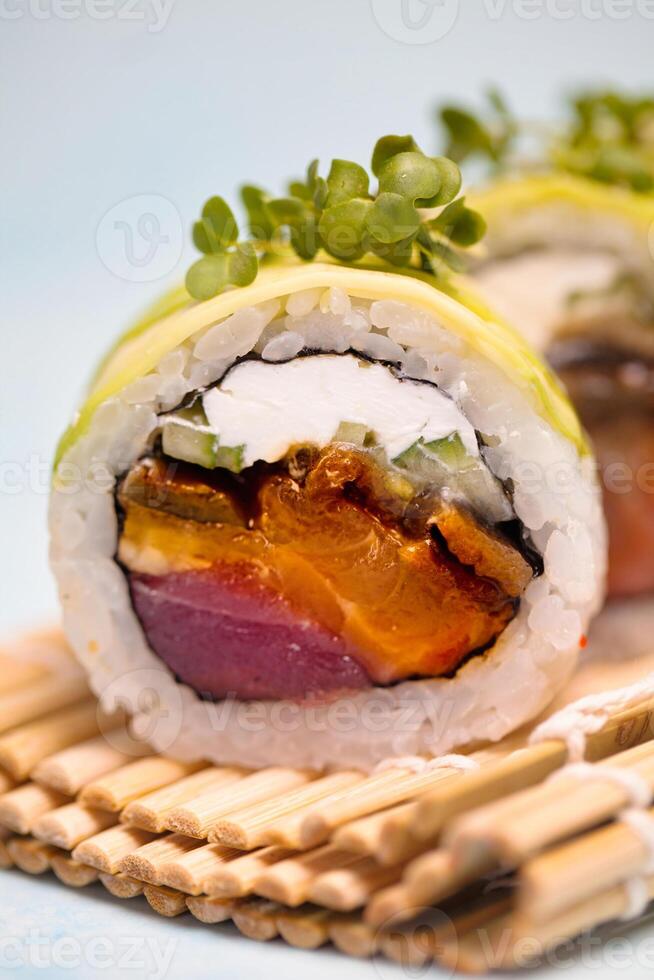 zwei Sushi Rollen auf ein Teller mit Essstäbchen foto