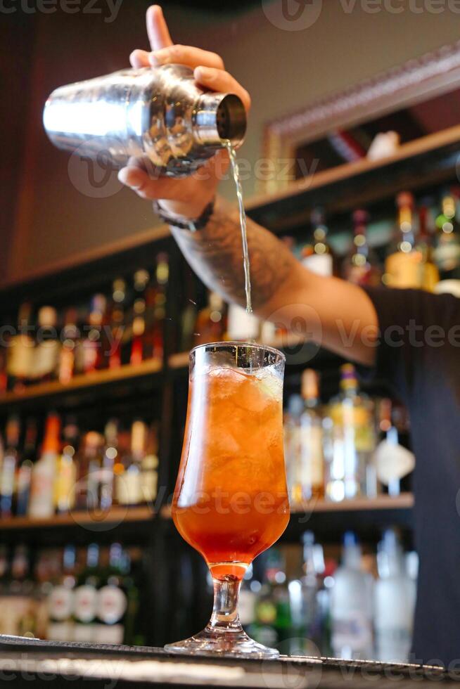 Barmann Gießen Whiskey in ein Martini Glas foto