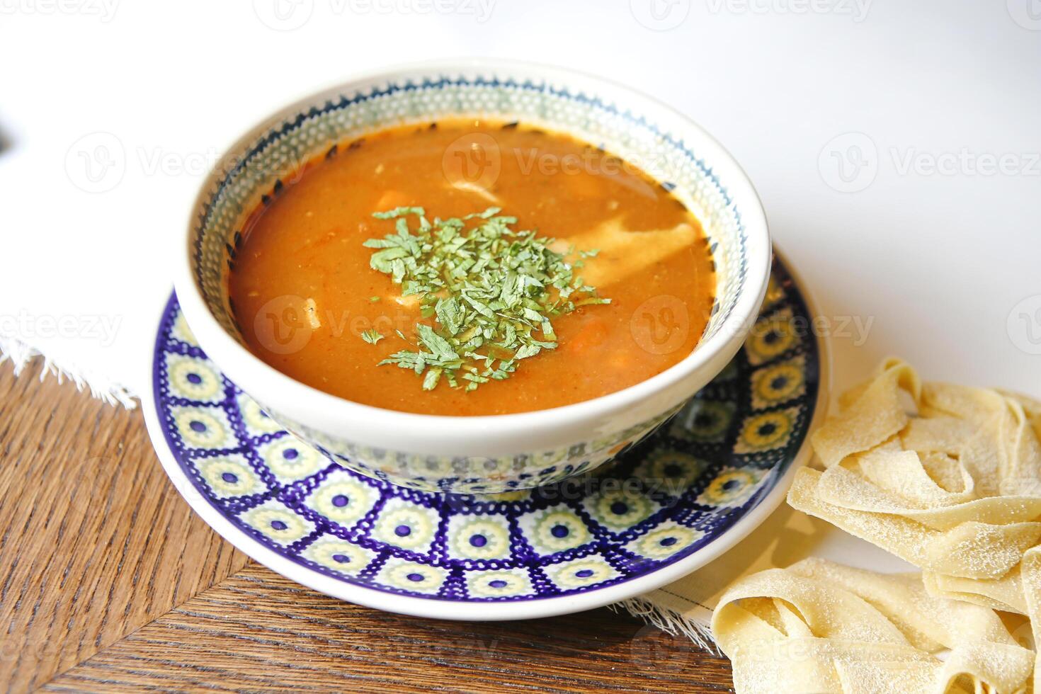 Schüssel von Suppe auf Blau und Weiß Teller foto