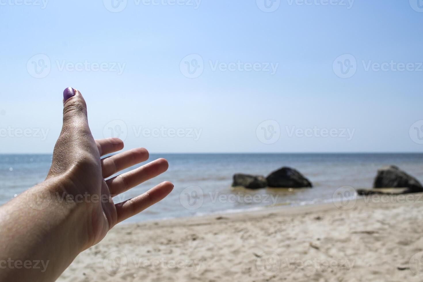 Mädchen Hand gegen Seelandschaft Hintergrund. foto