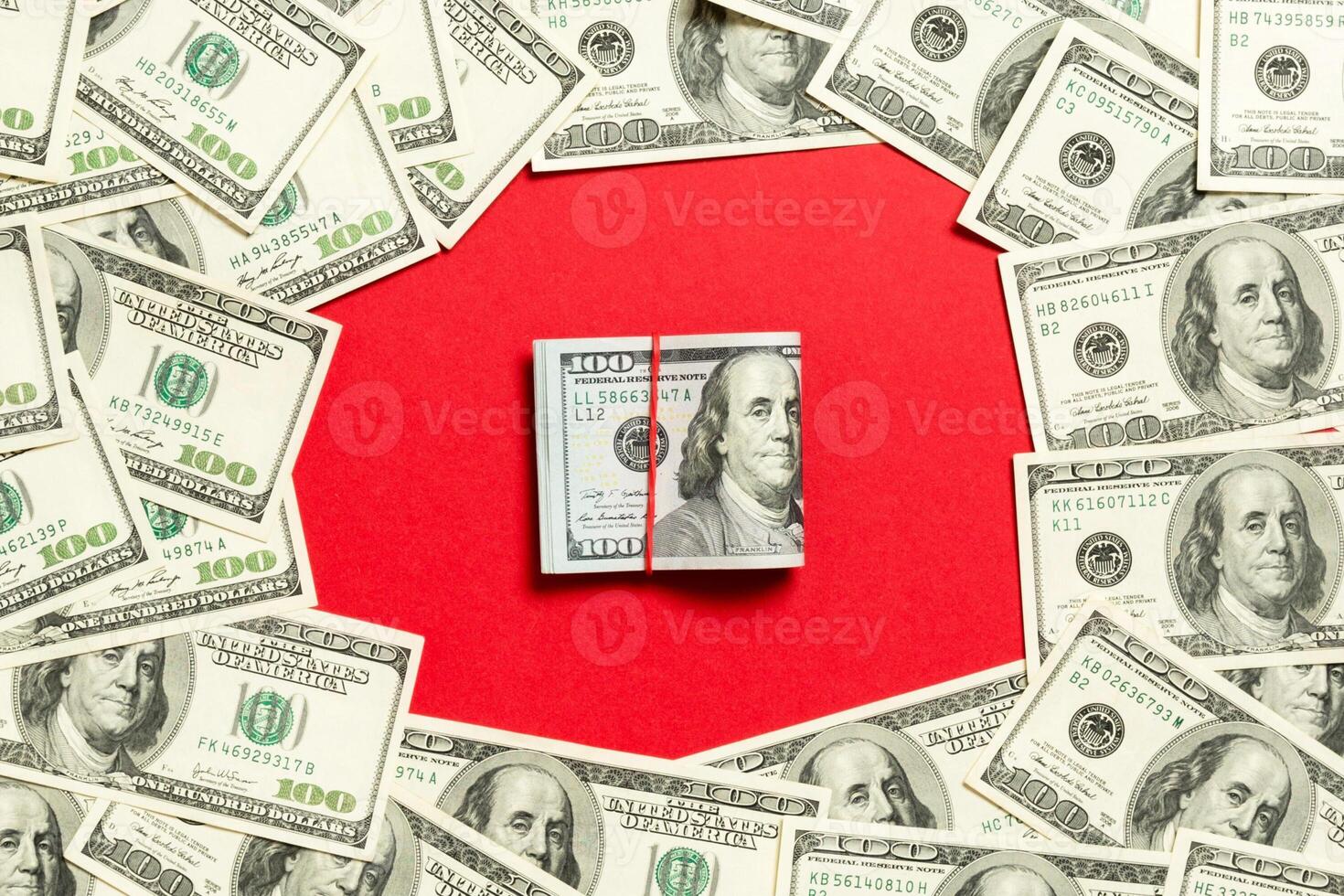 Rahmen von Hundert-Dollar-Scheinen mit Geldstapel in der Mitte. Draufsicht des Geschäftskonzepts auf rotem Hintergrund mit Kopienraum foto