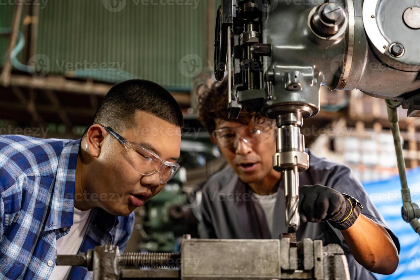 asiatisch Arbeiter im Produktion Pflanze Bohren beim Maschine. Fachmann Arbeiter in der Nähe von Bohren Maschine auf Fabrik. Fertigstellung Metall Arbeiten intern Stahl Oberfläche auf Drehbank Schleifer Maschine mit fliegend Funken. foto