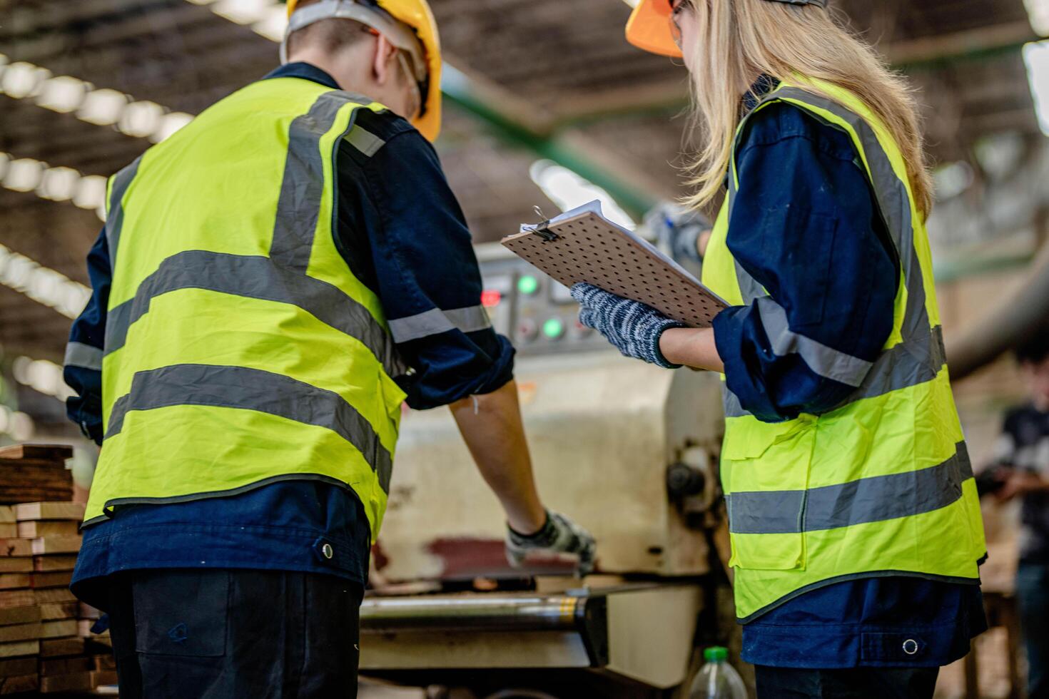 Arbeiter Tischler Arbeiten im Maschinen zu Schnitt Holz Holz. Mann und Frau sind basteln mit Holz im ein Werkstatt. zwei Handwerker oder Handwerker Arbeiten mit Zimmermann Werkzeuge oder elektrisch Maschinen. foto