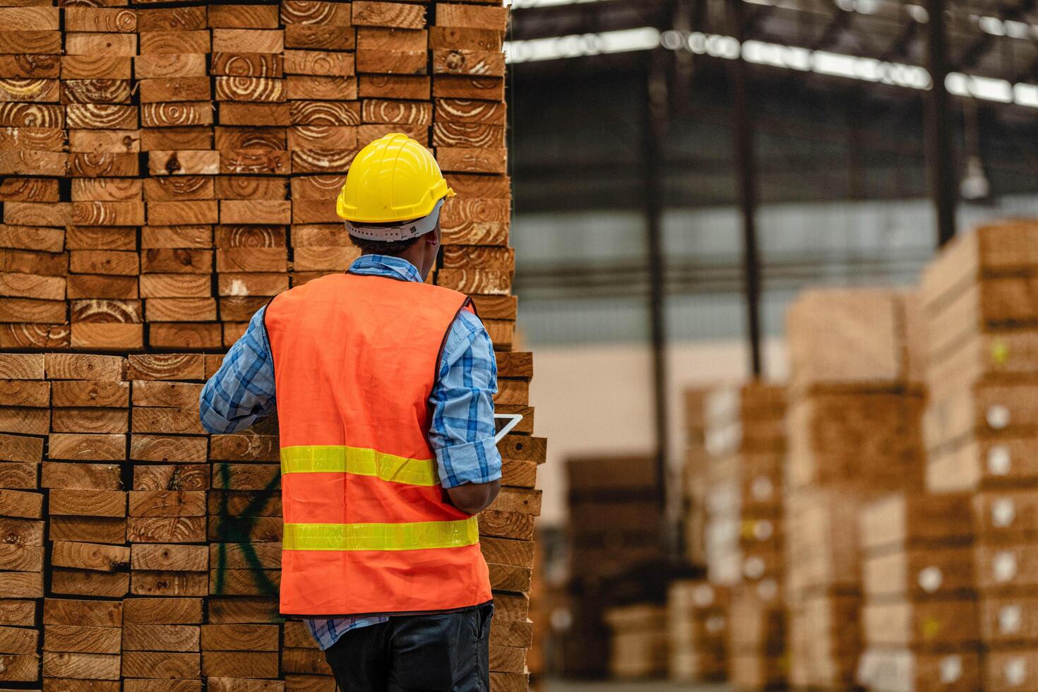 afrikanisch Arbeiter Zimmermann tragen Sicherheit Uniform und schwer Hut Arbeiten und Überprüfung das Qualität von hölzern Produkte beim Werkstatt Herstellung. Mann und Frau Arbeitskräfte Holz im dunkel Warenhaus Industrie. foto