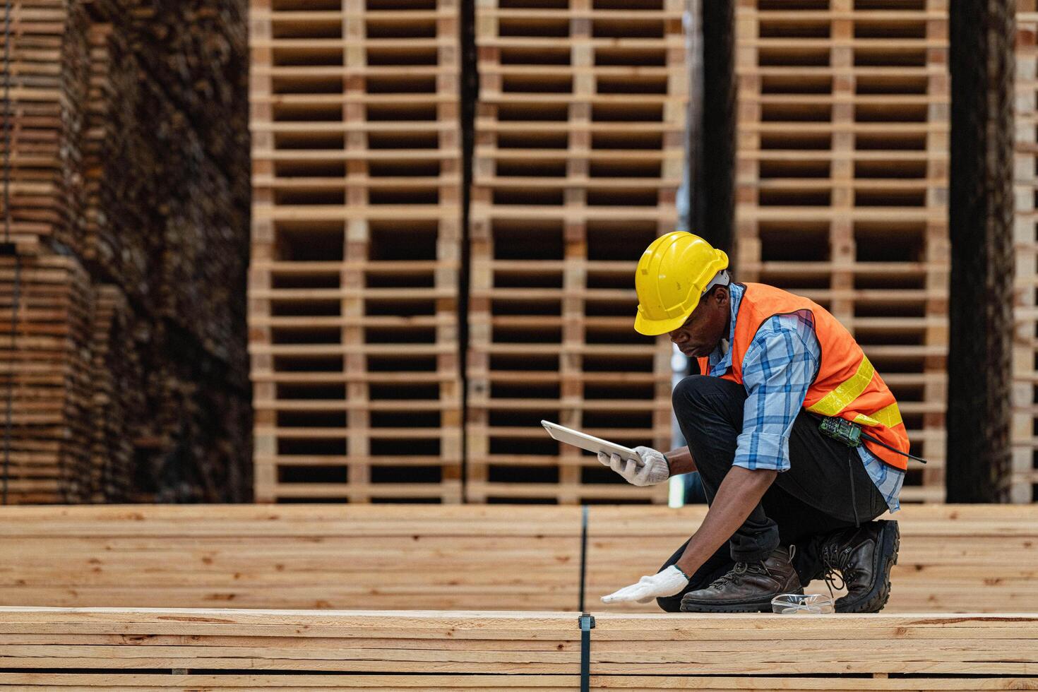 afrikanisch Arbeitskräfte Mann Ingenieurwesen Gehen und inspizieren mit Arbeiten Suite Kleid und Hand Handschuh im Bauholz Holz Lagerhaus. Konzept von Clever Industrie Arbeiter Betriebs. Holz Fabriken produzieren Holz Gaumen. foto