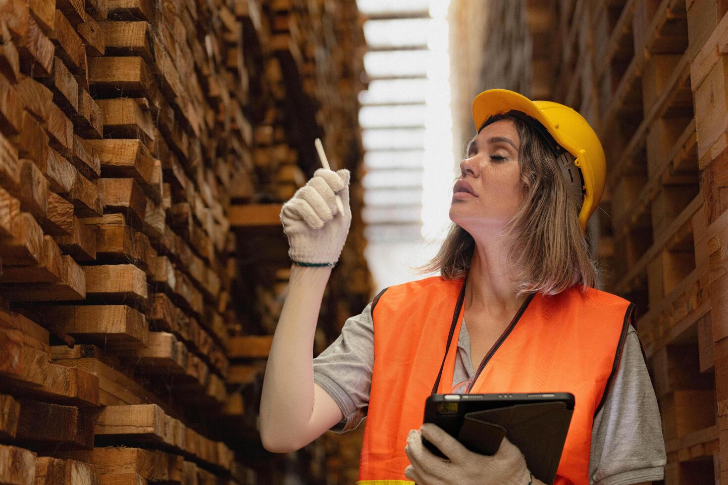 Frau Arbeiter Zimmermann tragen Sicherheit Uniform und schwer Hut Arbeiten und Überprüfung das Qualität von hölzern Produkte beim Werkstatt Herstellung. Mann und Frau Arbeitskräfte Holz im dunkel Warenhaus Industrie. foto