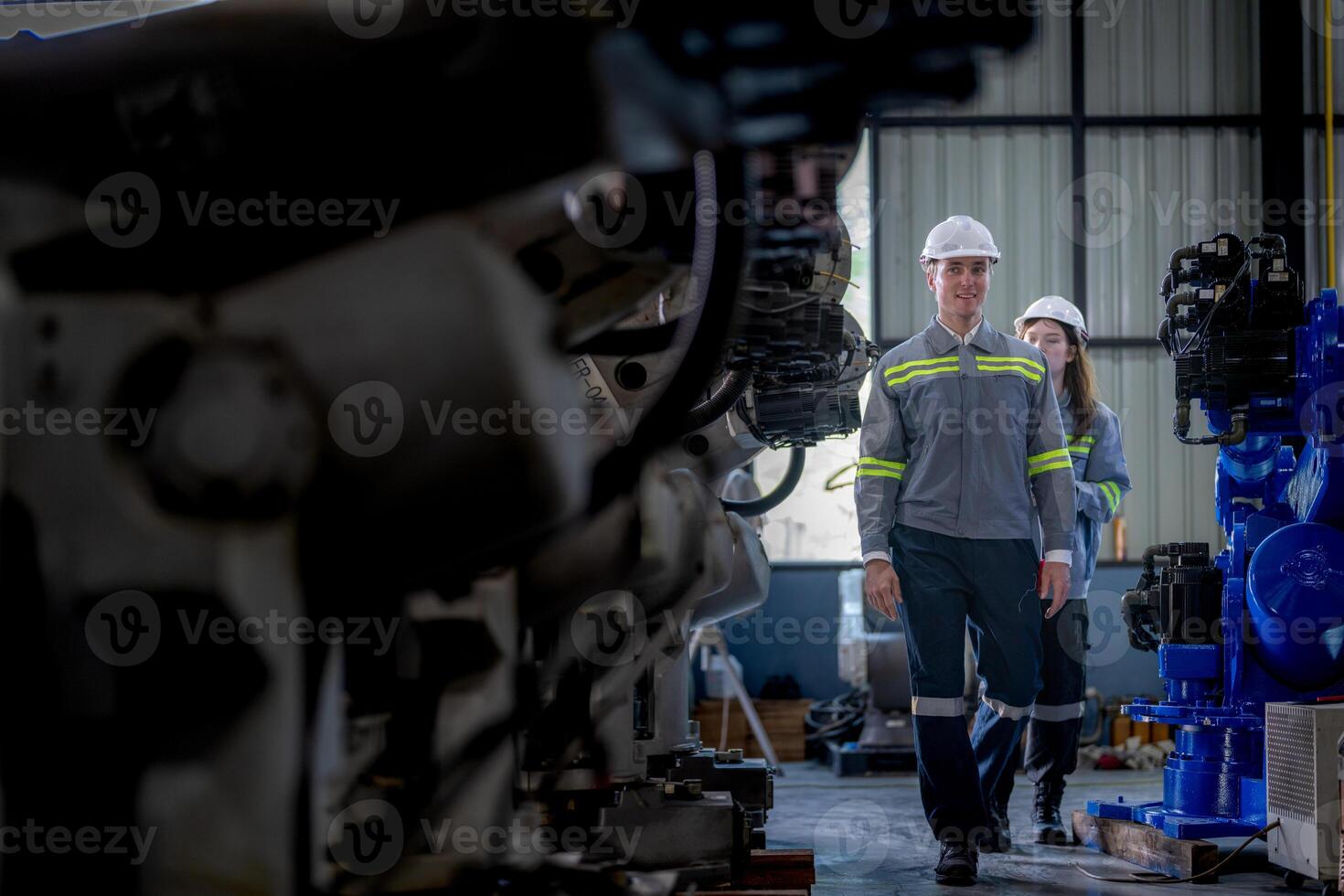 Fabrik Ingenieur Frau inspizieren auf Maschine mit Clever Tablette. Arbeiter funktioniert beim Maschine Roboter Arm. das Schweißen Maschine mit ein Fernbedienung System im ein industriell Fabrik. künstlich Intelligenz Konzept. foto