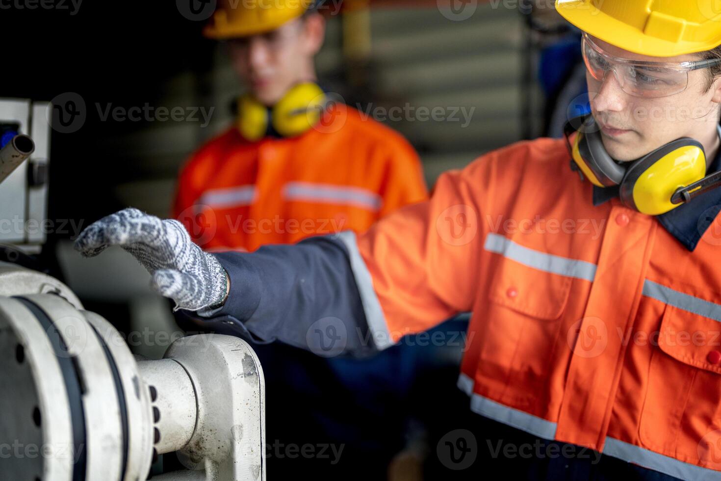 Ingenieur Mann Überprüfung das Status von Maschine und benutzt Schlüssel zu Schraube etwas Teil von Ausrüstung beim cnc Fabrik. Arbeiter tragen Sicherheit Brille und Helm. Instandhaltung und reparieren Konzept. foto