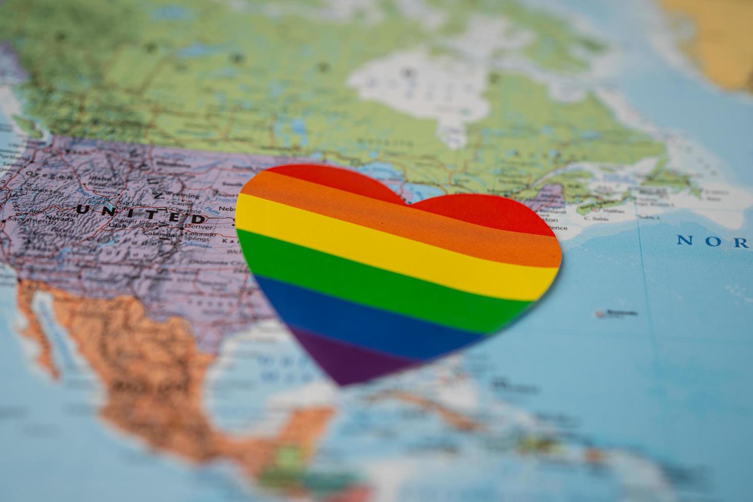 Regenbogenfarbenherz auf Amerika-Globus-Weltkartenhintergrund, Symbol des LGBT-Stolzmonats feiern jährlich im Juni Soziales, Symbol für Schwule, Lesben, Schwule, Bisexuelle, Transgender, Menschenrechte und Frieden. foto