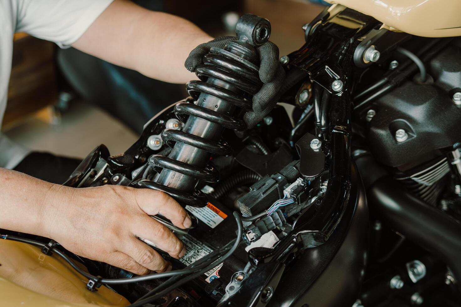 Motorrad Mechaniker prüfen und Veränderung Rückseite Schock Absorber Motorrad beim Motorrad Garage, Reparatur, Instandhaltung und Bedienung Konzept foto