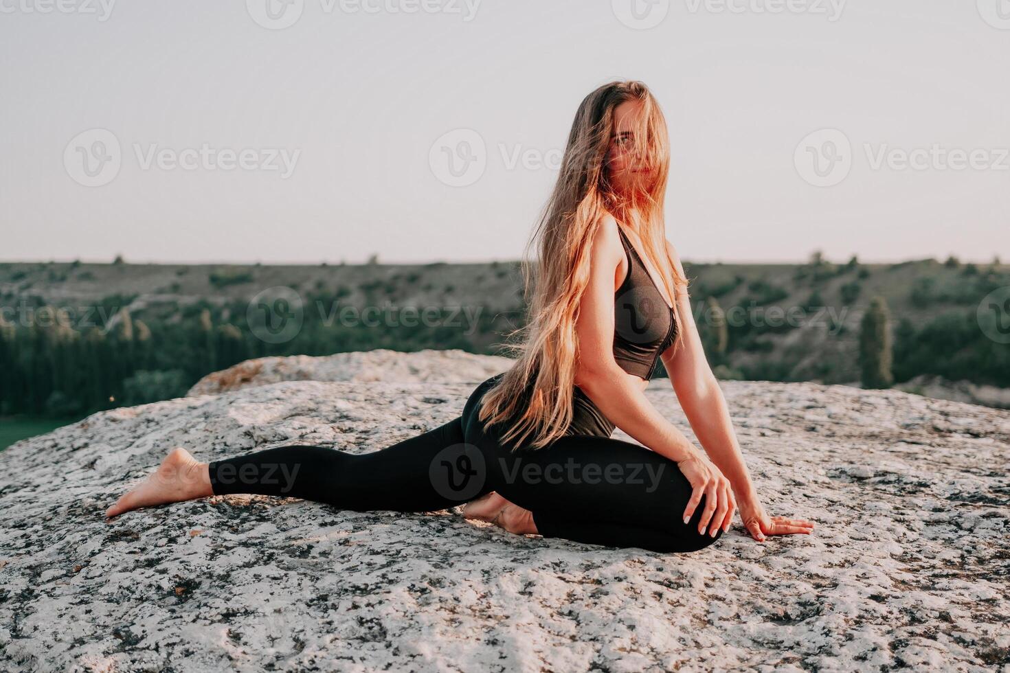 Fitness Frau. Gut suchen Mitte alt Frau mit lange Haar, Fitness Lehrer im Gamaschen und Spitzen tun Dehnen und Pilates auf das Felsen in der Nähe von Wald. weiblich Fitness Yoga Routine Konzept. foto