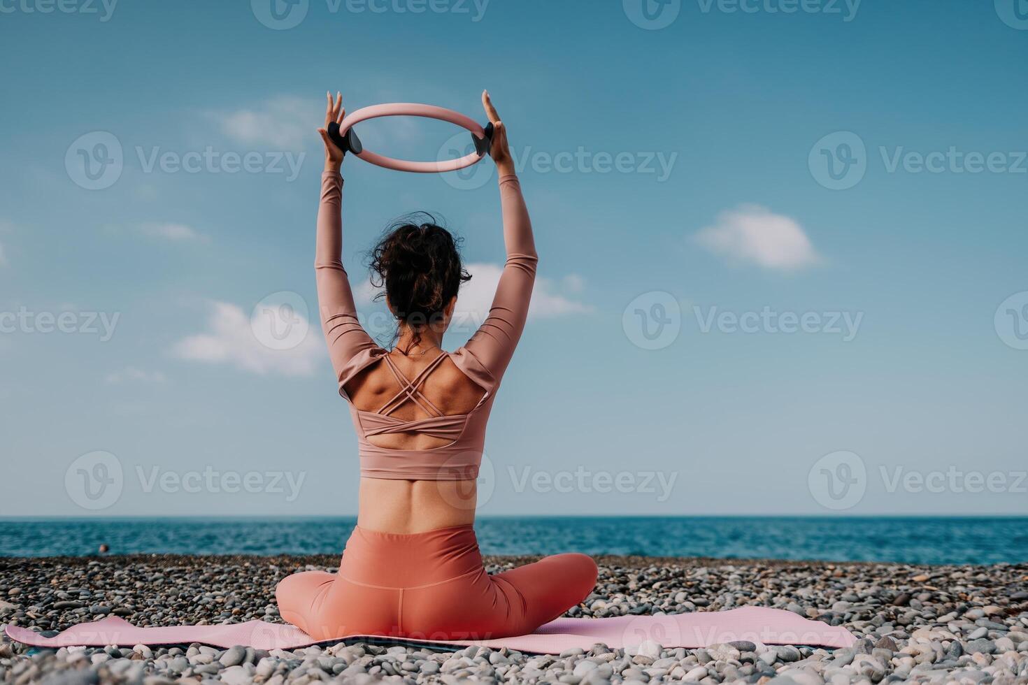 Frau Meer Pilates. sportlich glücklich Mitte alt Frau üben Fitness auf Strand in der Nähe von Meer, lächelnd aktiv weiblich Ausbildung mit Ring auf Yoga Matte außen, genießen gesund Lebensstil, Harmonie und Meditation foto