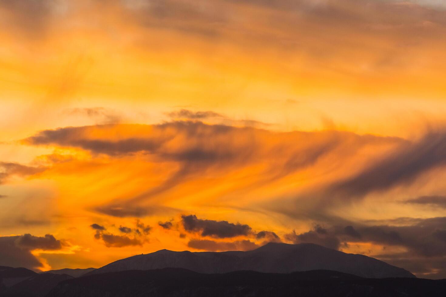 tolle Wolken mit Sturm während Sonnenuntergang im ein eben Landschaft mit ein Berg foto