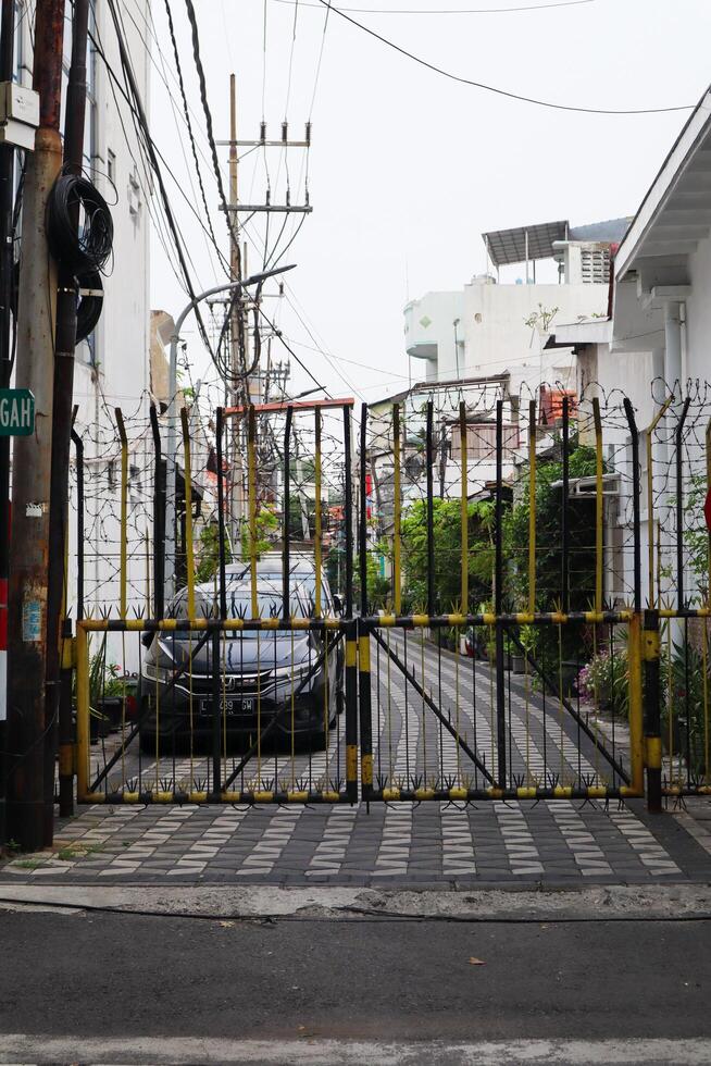 Wohn Zaun Tor mit mit Widerhaken Kabel. Surabaya, Indonesien - - 21 Februar 2024 foto