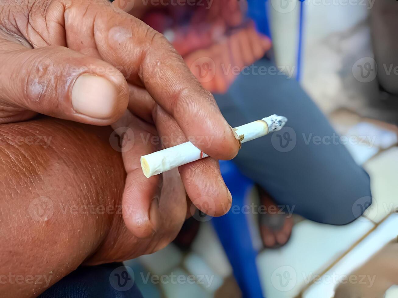 ein Nahansicht von ein des Mannes Hand halten ein Zigarette. ein Bild Das erfasst das Detail von das Hand halten das Zigarette. geeignet zum Gesundheit Risiken, oder Lebensstil Auswahlmöglichkeiten. foto