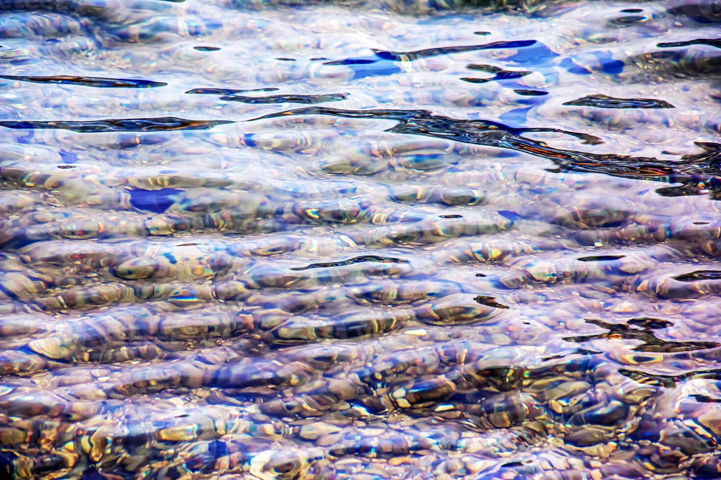Hintergrund von das Wasser von See traunsee im das Küsten Bereich. bunt Textur von Steine unter Wasser. foto