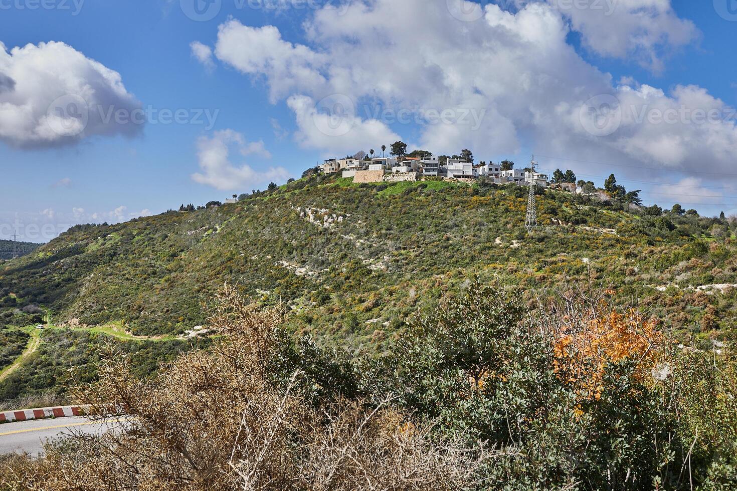 felsig Hügel mit ein Schmutz Straße im Vorderseite unter ein Blau Himmel mit Weiß Wolken und ein modern Villa auf oben foto