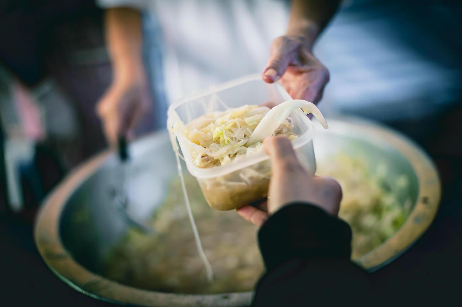 Arm Menschen erhalten gespendet Essen von Spender das Hände von das Arm erhalten Essen von das Hände von das menschlich foto