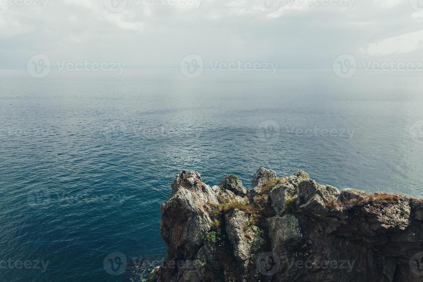 Scharf Klippen hängen Über das Ozean, dramatisch Marine Hintergrund foto
