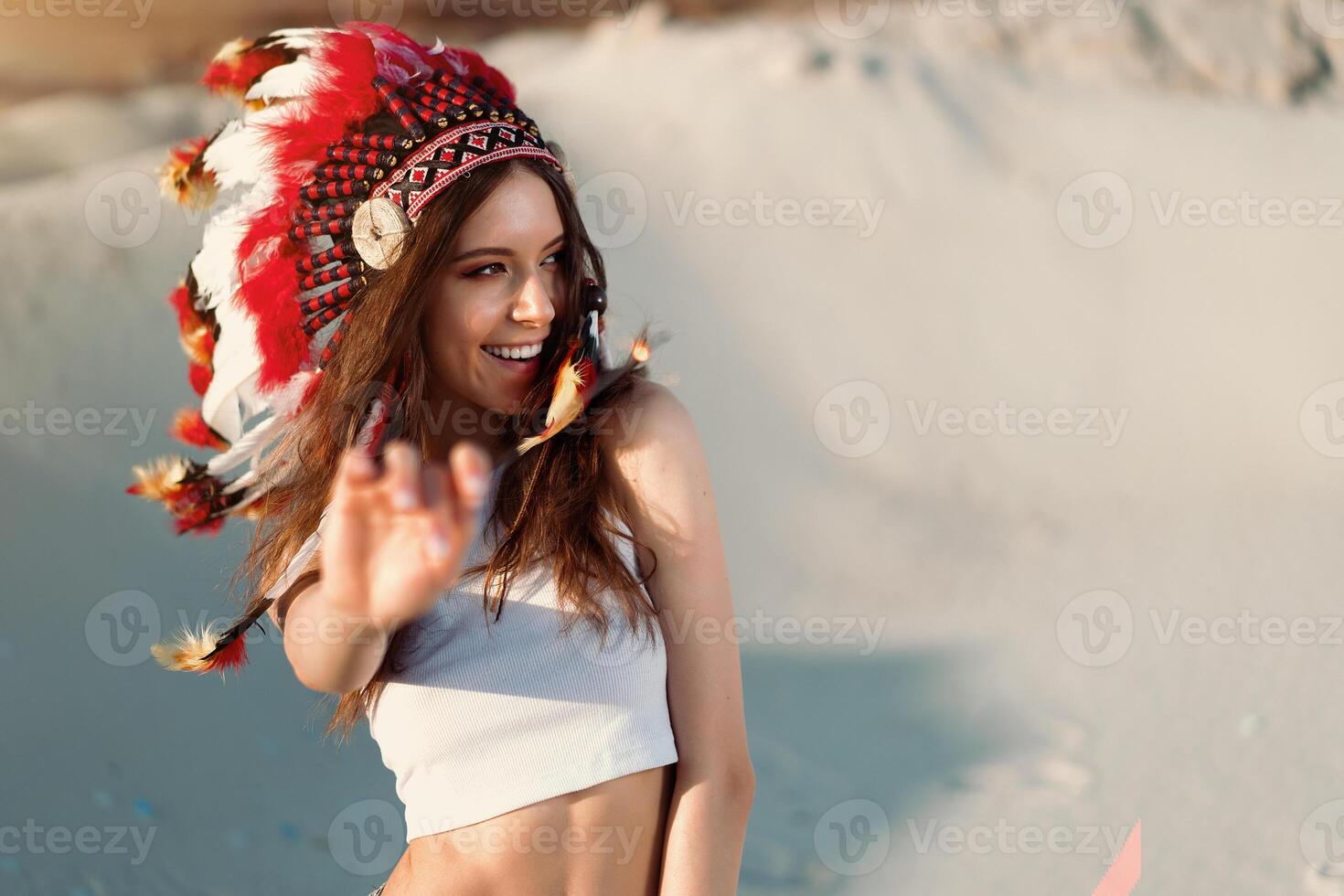 ein schön jung kaukasisch Mädchen im ein Weiß oben auf ihr Kopf ist tragen ein indisch Hut. Plötze ist im das Wüste. glücklich Urlaub Stimmung. foto