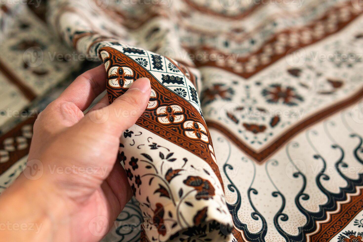 ein Hand halten traditionell indonesisch Stoff, nämlich Batik Tuch. Indonesien mit elegant klassisch Motiv foto