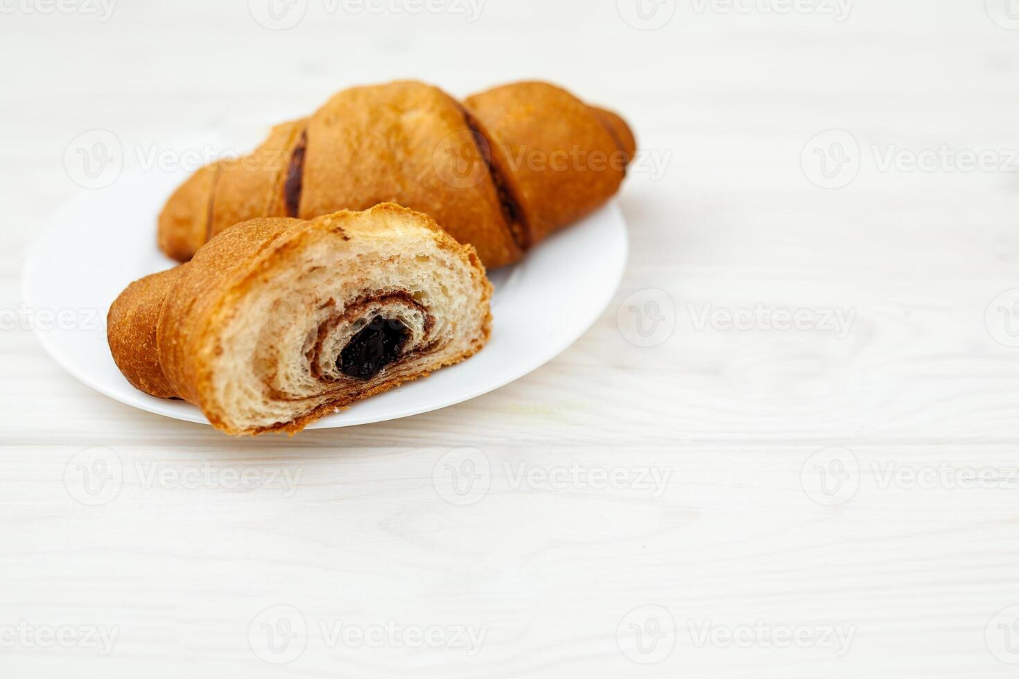 frisch Croissant mit Schokolade auf das Weiß hölzern Hintergrund foto