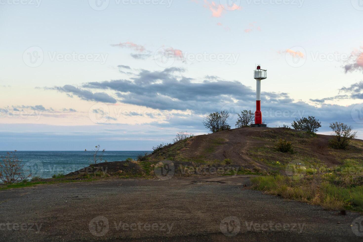 weiß Rot Leuchtturm auf das direkt am Meer foto