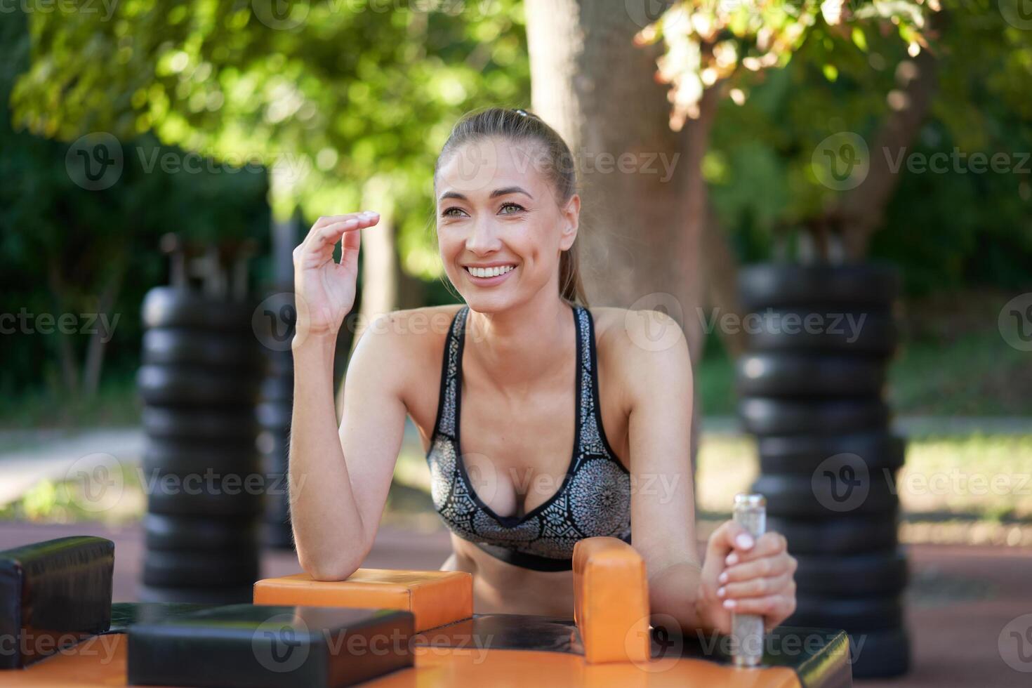 sportlich weiblich Arm Ringen draussen Fitnessstudio Sommer- Park foto