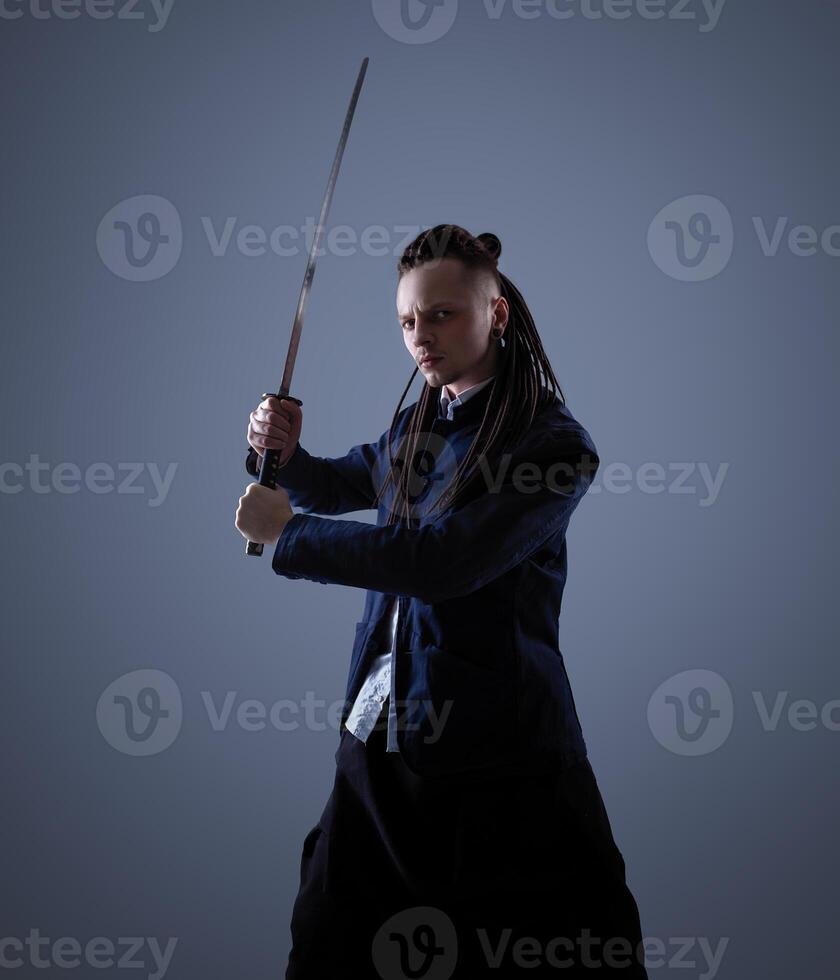 jung Mann halten ein Samurai Schwert. Glanz Foto. foto