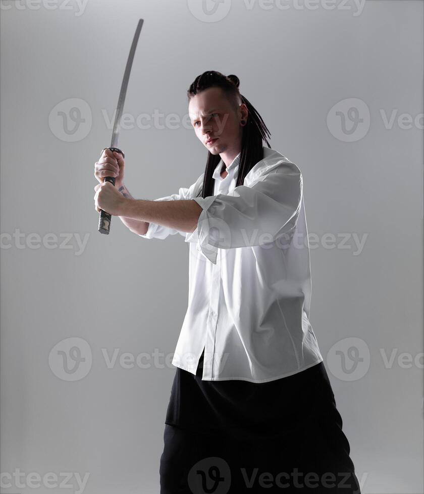 jung Mann halten ein Samurai Schwert. Glanz Foto. foto