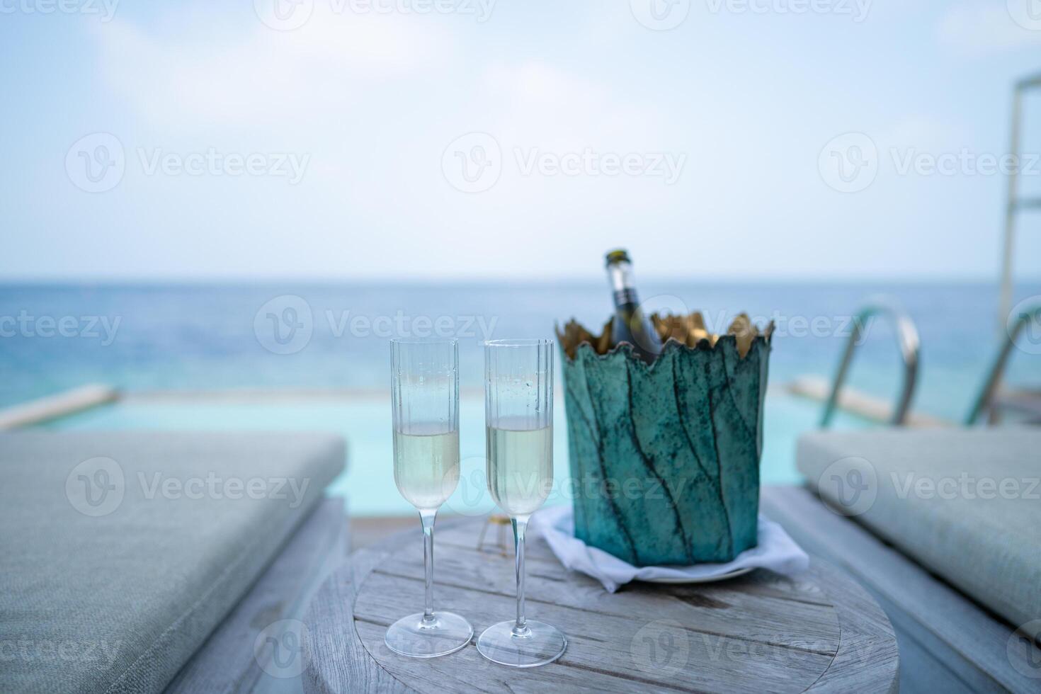 ein Champagner Flasche auf Eimer gefüllt mit Eis auf mit tropisch Ozean Hintergrund. foto