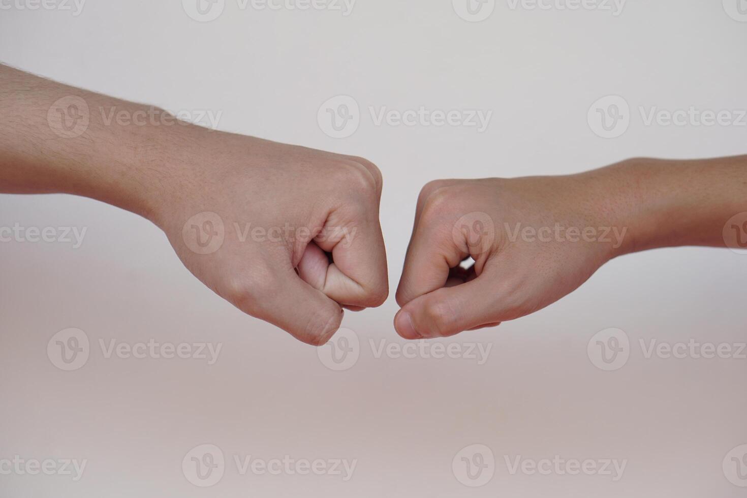 schließen oben zwei Hände stoßen ihr Fäuste zusammen zum Gruß. Konzept, Körper Sprache. Hände Geste Symbol zum Gruß, geben Respekt oder die Genehmigung wie Gesellschaft zwischen zwei Personen. foto
