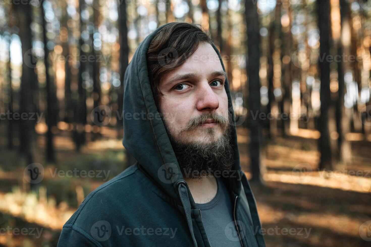 Mann ist Stehen im das Wald und gerade entspannend gekleidet mögen Homies im dunkel Blau Goodie foto