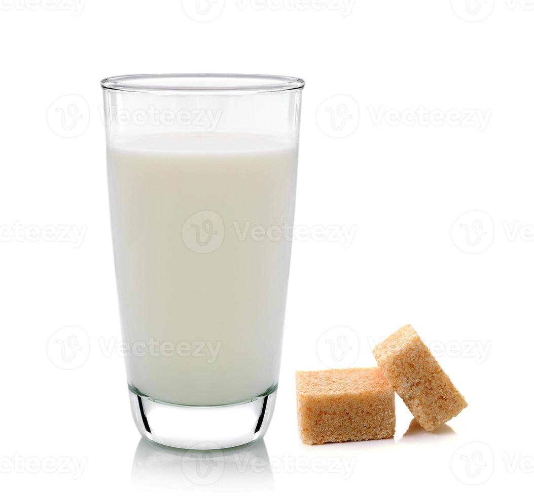 Glas Milch und Rohrzuckerwürfel auf weißem Hintergrund foto