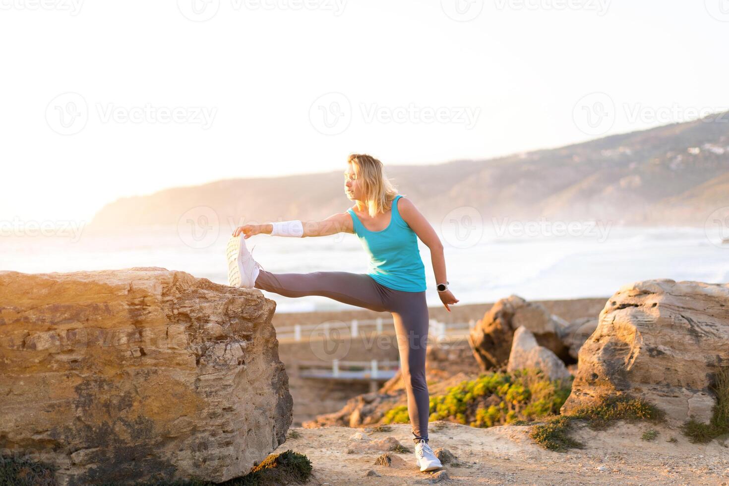 flexibel kaukasisch Mädchen erstreckt sich Beine nach ein intensiv Laufen trainieren. sportlich weiblich Mitte Alter Erwärmen oben Vor Joggen trainieren draussen foto