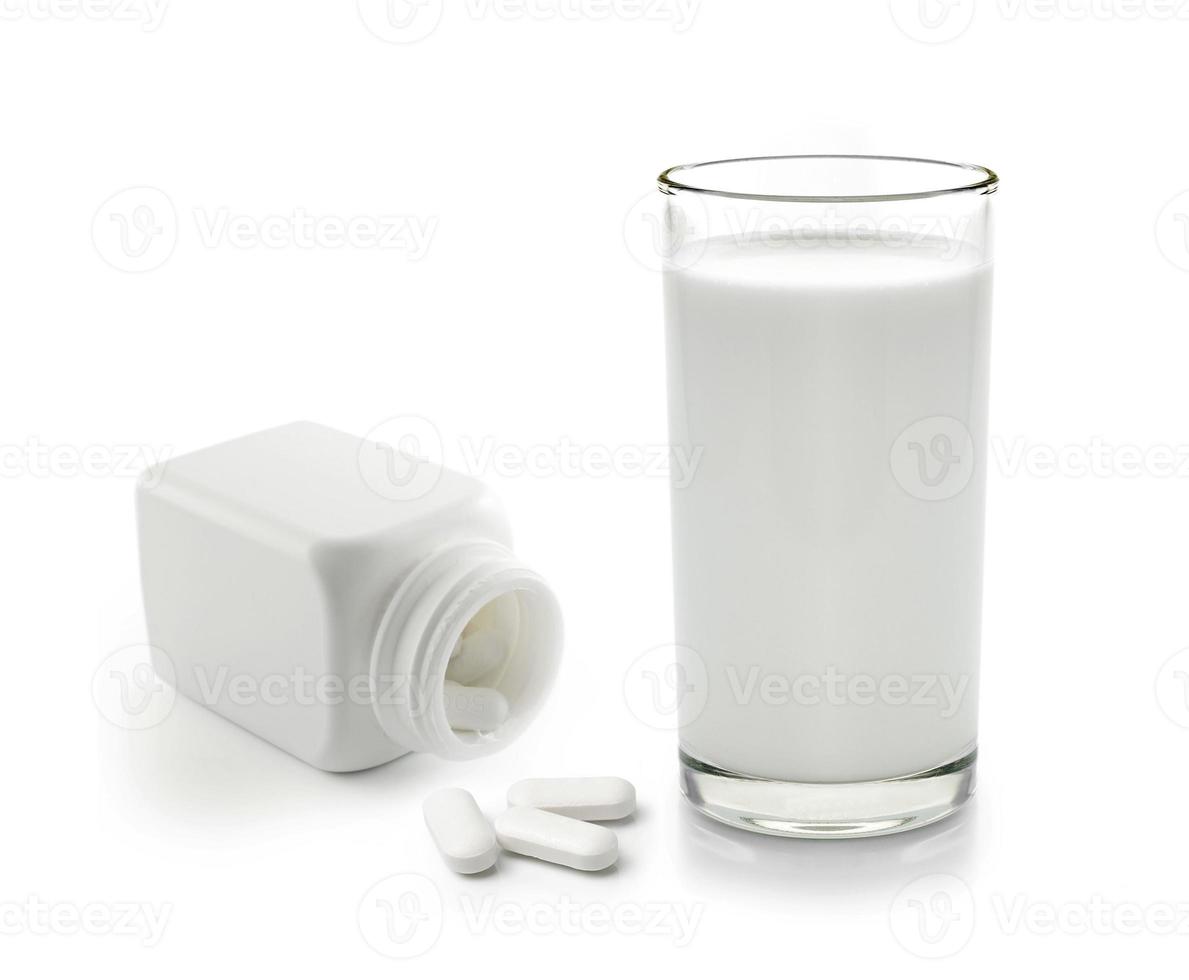 Pille und Glas Milch auf weißem Hintergrund foto