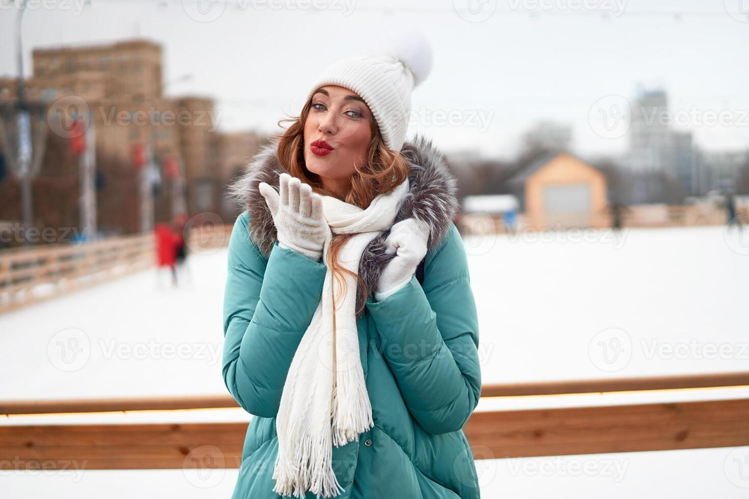 schön schön mittleren Alters Mädchen mit lockig Haar warm Winter Jacken steht Eis Eisbahn Hintergrund Stadt, Dorf Quadrat. foto