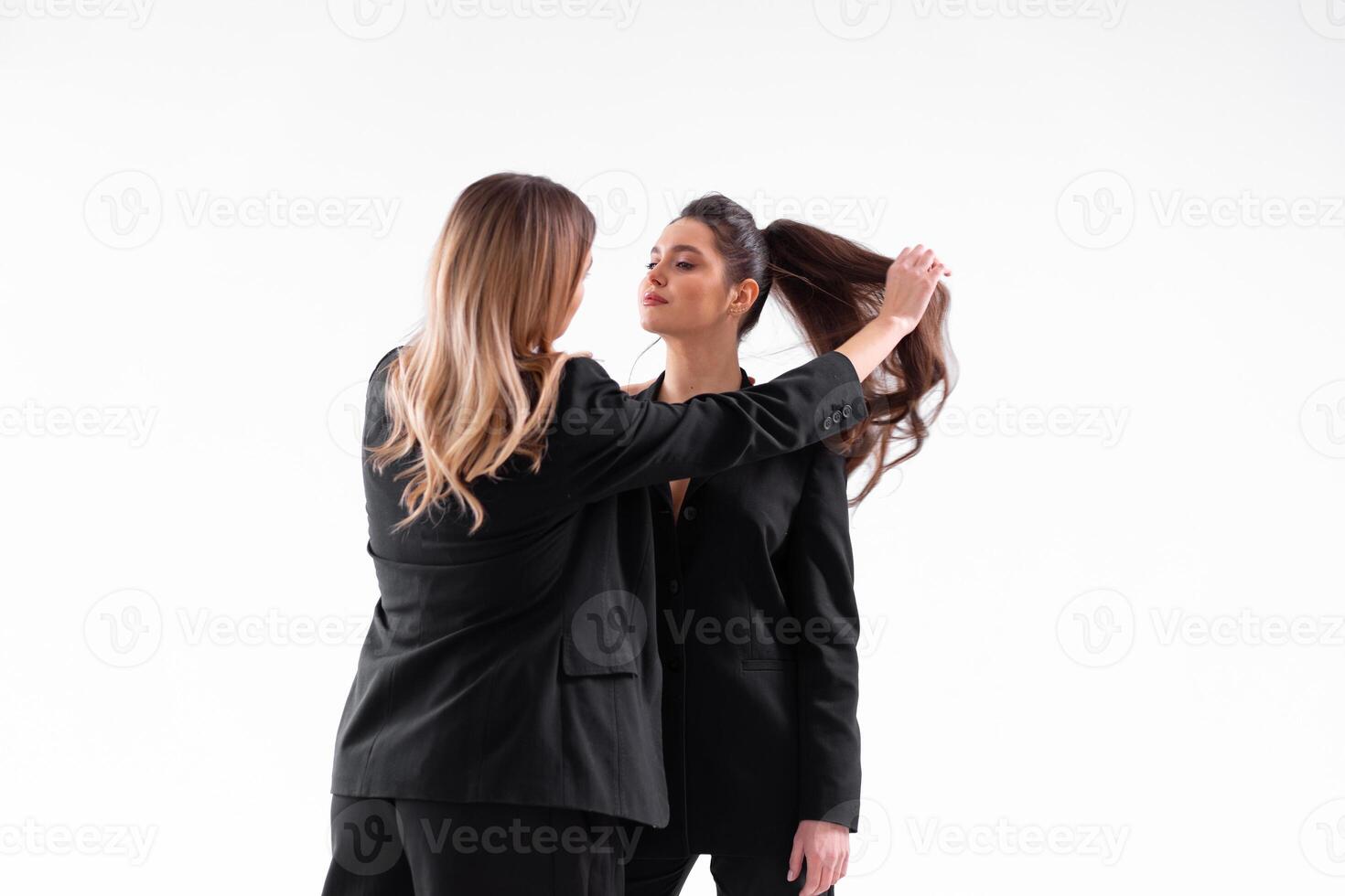 Konzept von Partnerschaft im Geschäft. zwei jung Geschäftsfrau gekleidet schwarz formal passen Stehen Studio isoliert Weiß Hintergrund. foto