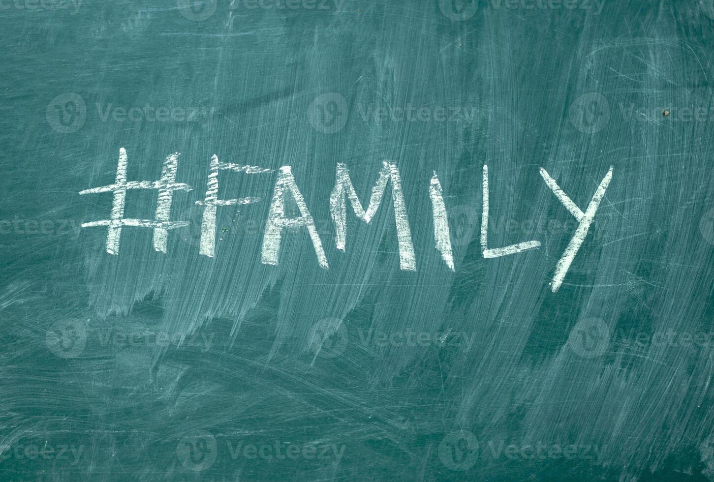 Familie Hashtag es handgeschrieben mit Weiß Kreide auf ein Grün Tafel foto