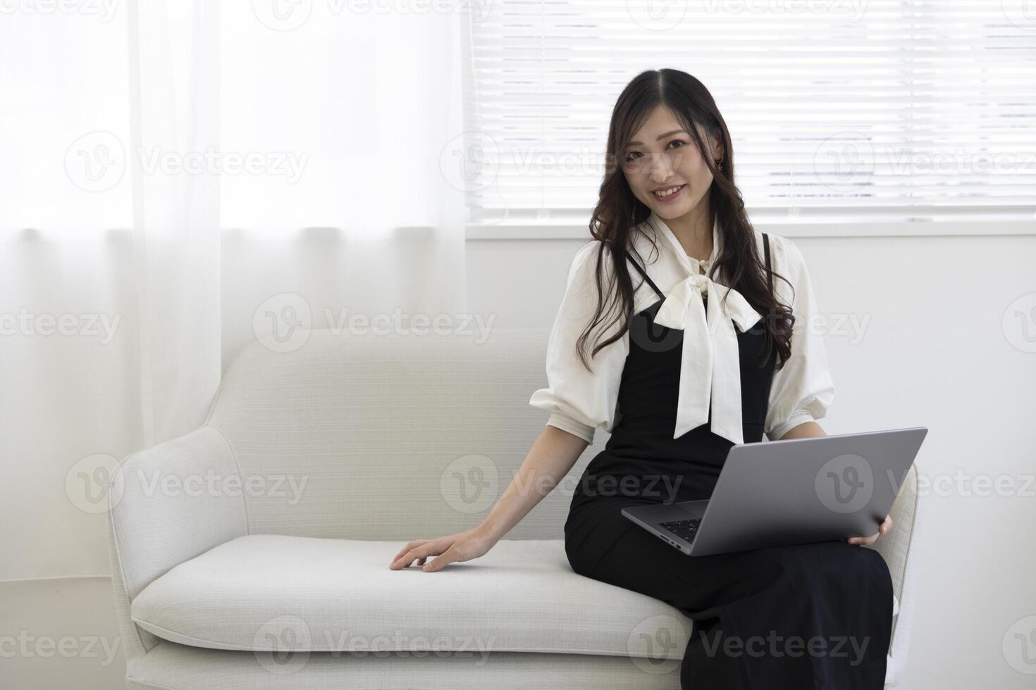 ein japanisch Frau Überprüfung Smartphone durch Fernbedienung Arbeit im das Zuhause Büro foto