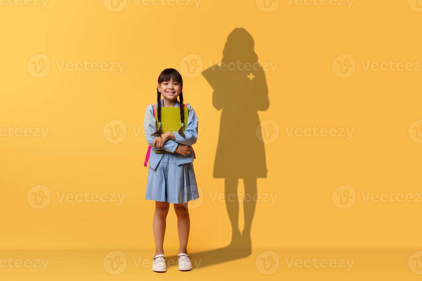 ein heiter jung Mädchen Verschlüsse ein Buch und lächelt, tragen ein Blau Kleid und Rucksack foto