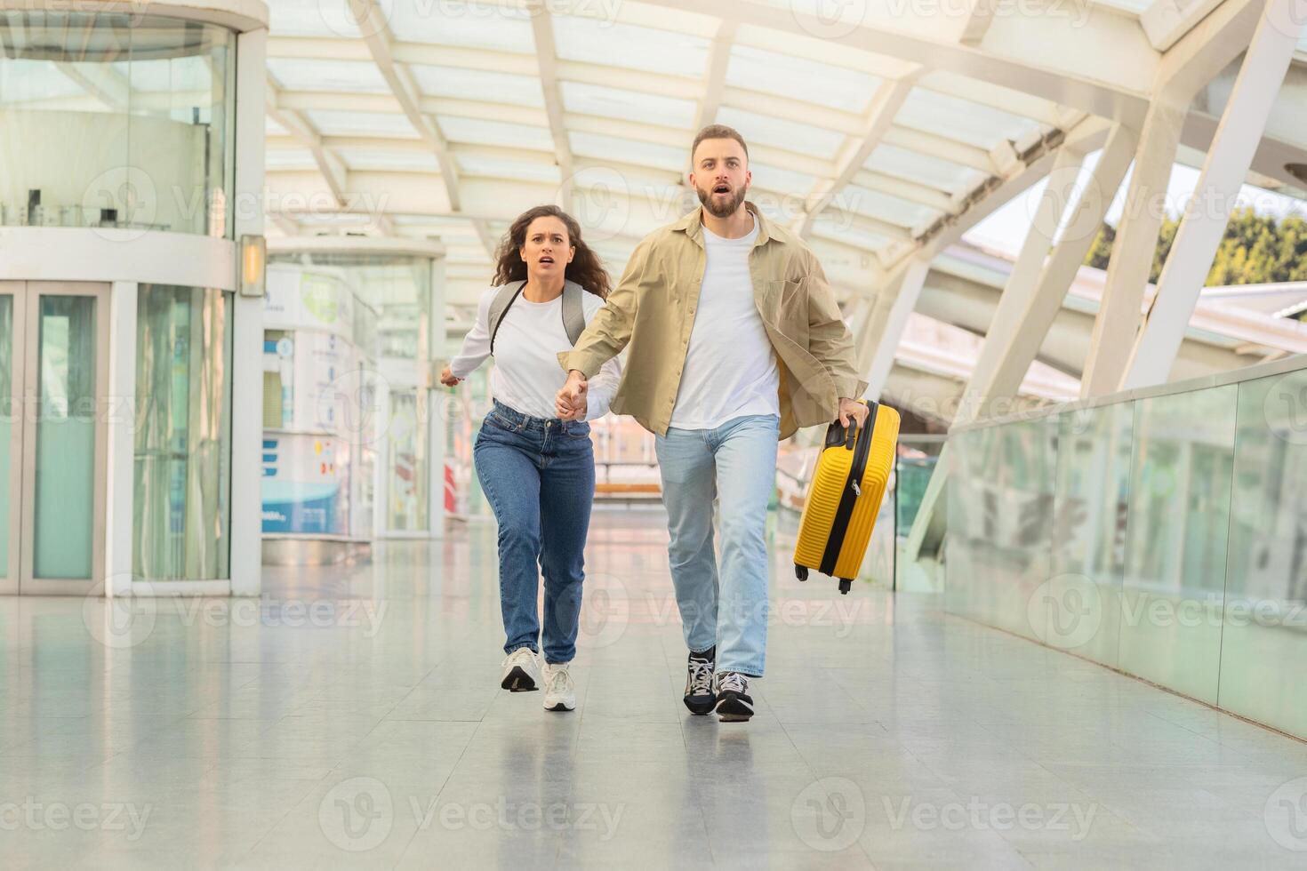 entschlossen Paar Sprinten durch Flughafen Gang mit Koffer, versuchen zu Fang Flug foto