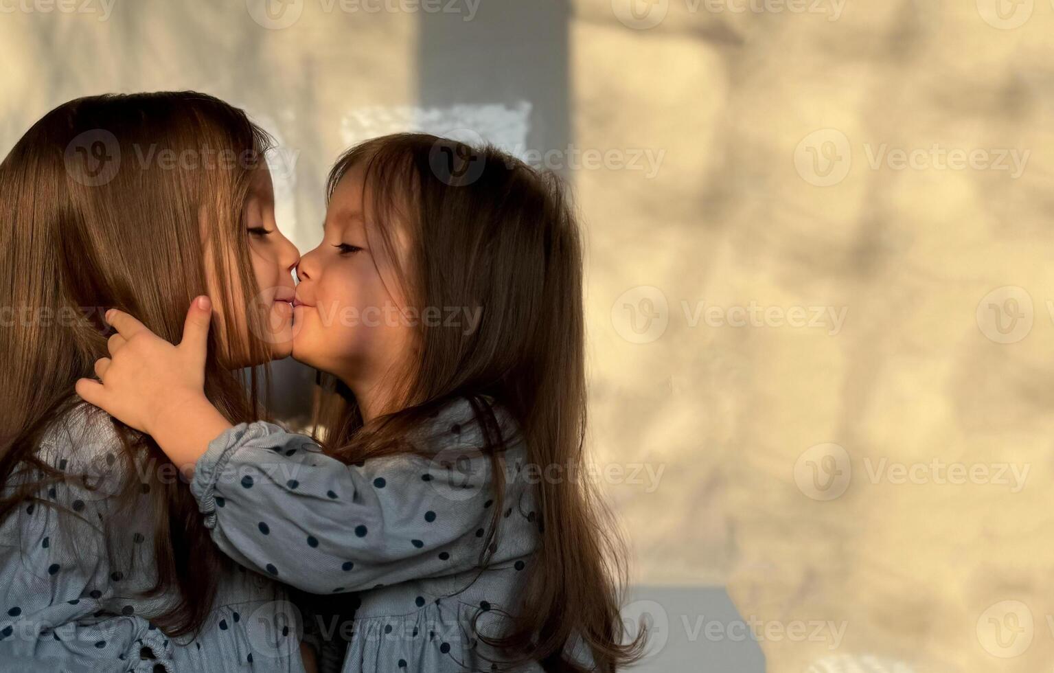 Porträt von gemischt Rennen Zwilling Baby Mädchen küssen und umarmen jeder andere. glücklich Geschwister Tag. foto