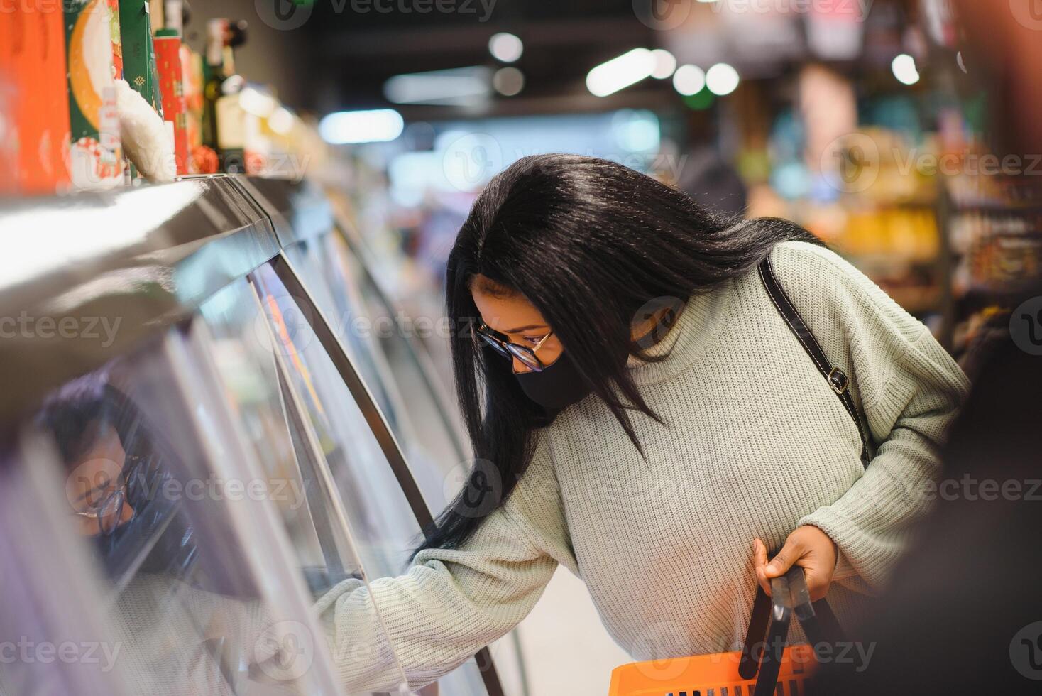 afrikanisch Frau tragen Einweg medizinisch Maske. Einkaufen im Supermarkt während Coronavirus Pandämie Ausbruch. Epidemie Zeit foto