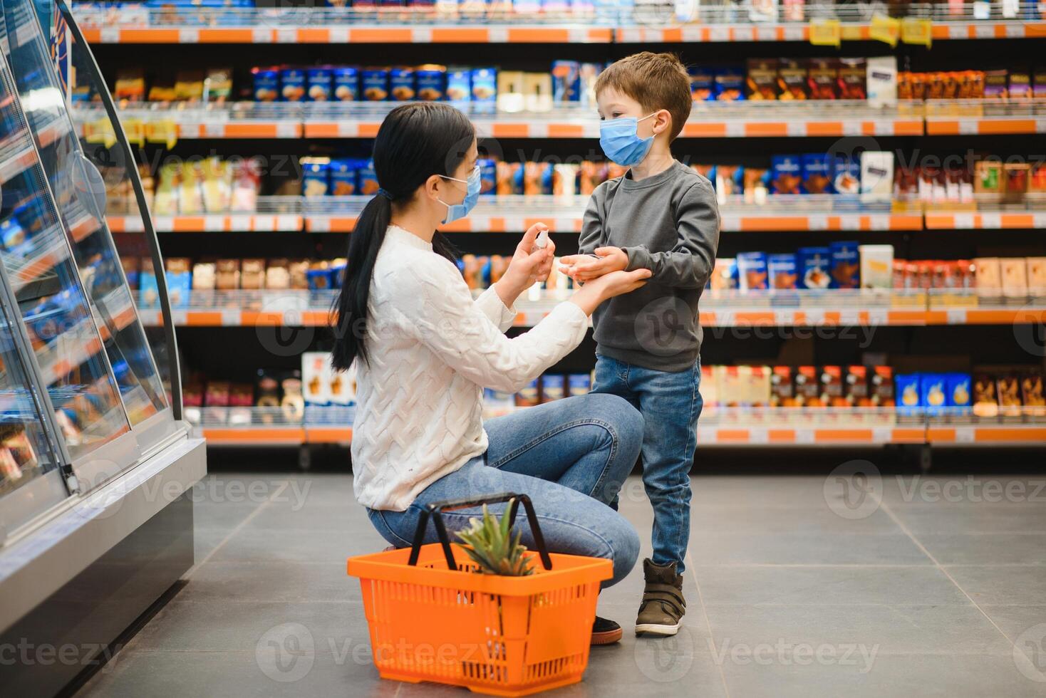 Frau desinfiziert ihr Sohn Hände im das Geschäft während Coronavirus und Grippe Ausbruch. foto