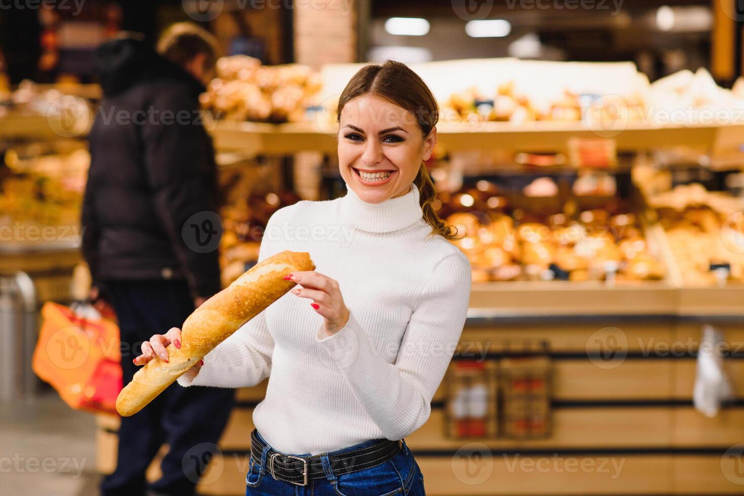 süß französische Frau im ein gestreift T-Shirt halten ein Stangenbrot im das Hände foto