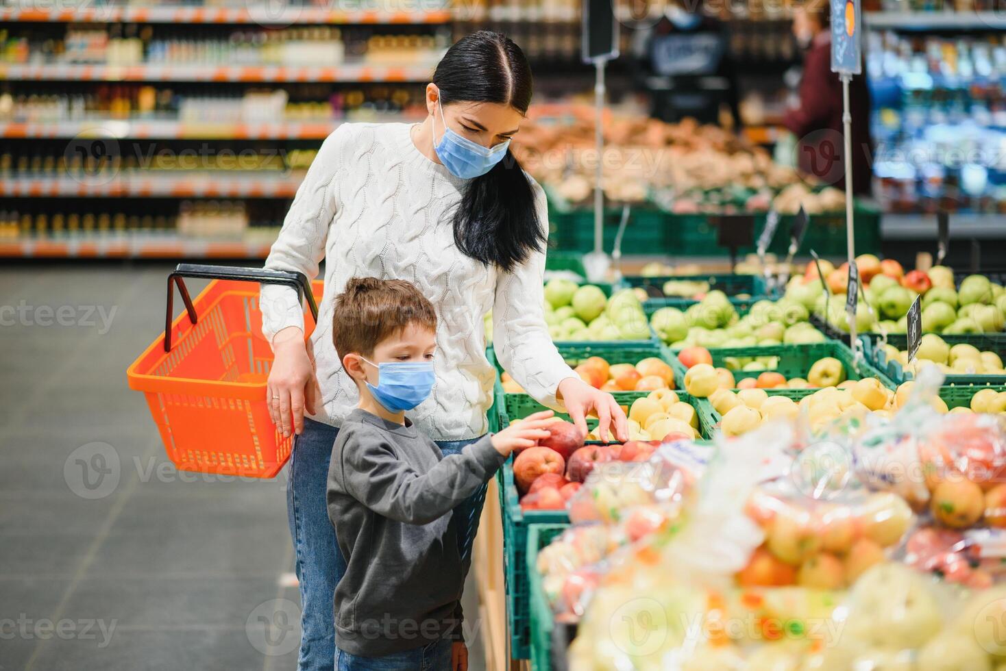 jung Frau und ihr wenig Sohn tragen schützend Gesicht Maske Geschäft ein Essen beim ein Supermarkt während das Coronavirus Epidemie oder Grippe Ausbruch. foto