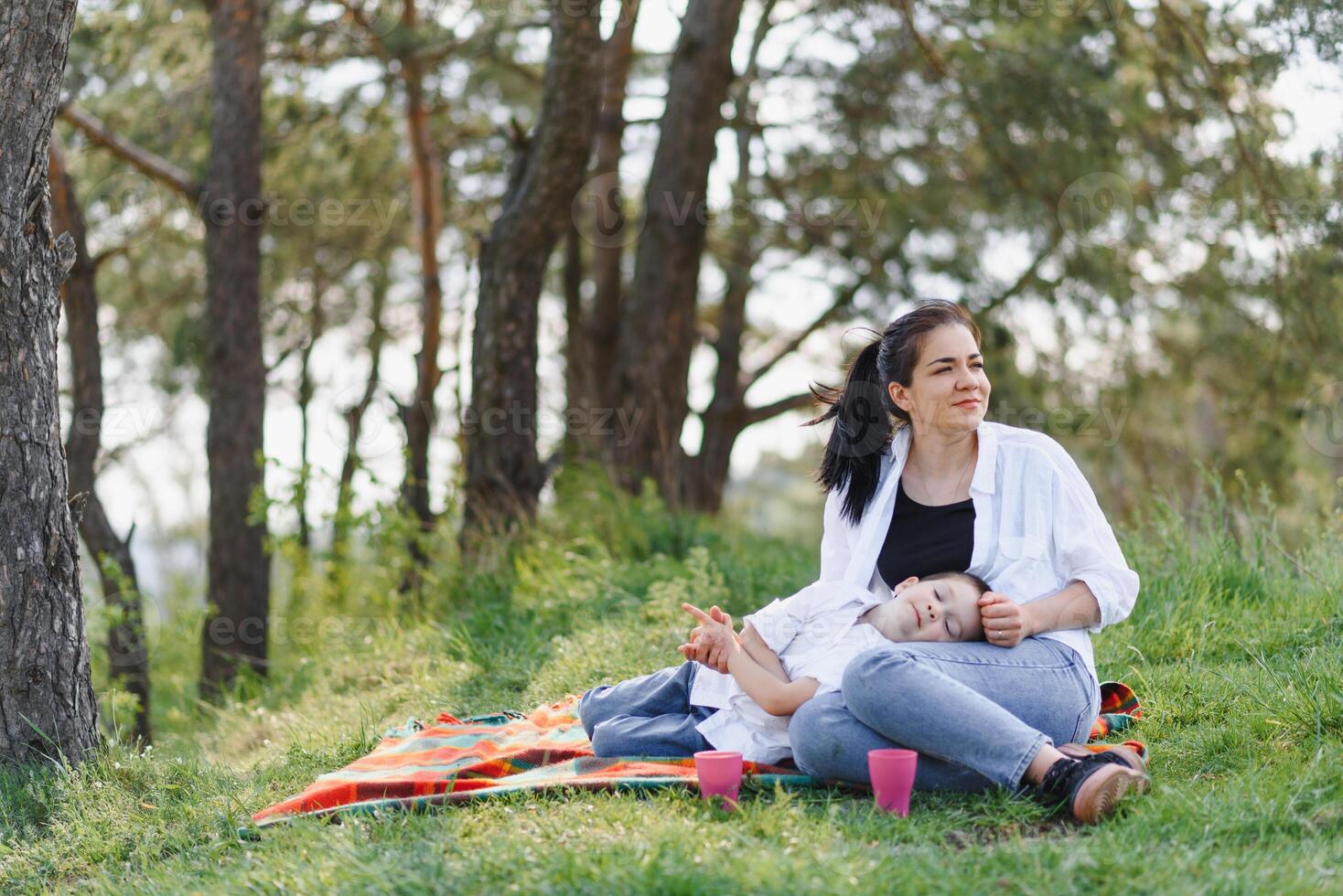 stilvoll Mutter und gut aussehend Sohn haben Spaß auf das Natur. glücklich Familie Konzept. Schönheit Natur Szene mit Familie draussen Lebensstil. glücklich Familie ruhen zusammen. Glück im Familie Leben. Mütter Tag. foto